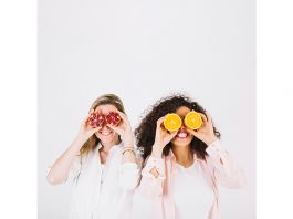 Two happy women having fruits for stress relief