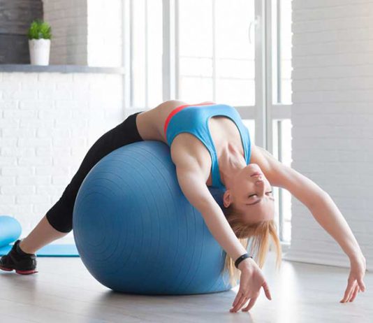 Fit sportswoman doing pilates with stability ball